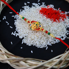 Ganesha With Green And Red Mina Rakhi With Decorative Baby Buddha Gift ,Silver Color Pooja Coin, Roli Chawal & Greeting Card